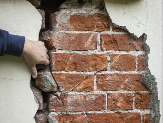 Hand inside of brick wall